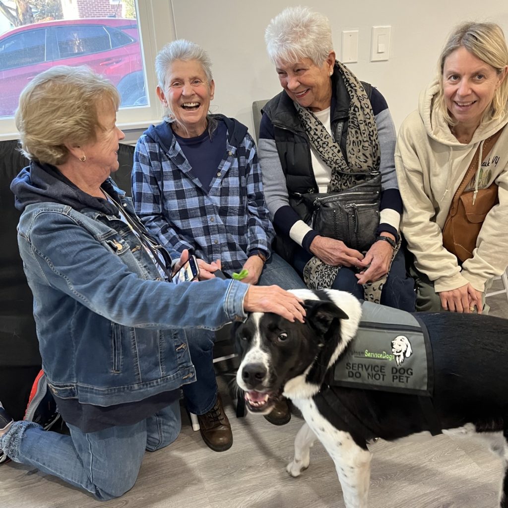 Group of elderly women around Putnam Service Dog